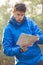 Young male hiker reading map in forest