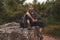 Young male hiker resting  on large rock in the french countryside ,adventure walking holiday