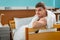 Young male ill patient leaning on the hospital bedstead covered