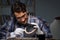 The young male jeweller working at night in his workshop