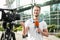 Young male journalist with microphone working