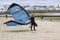 A young male kite surfer on the beach with his equipment