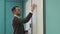 Young male lecturer writes on the whiteboard in classroom