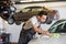 Young male mechanic cleaning car in repair shop