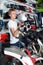 Young male motorcyclist sitting and choosing helmet