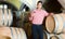 Young male owner of winery standing with wine