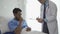 Young male patient having health check and consulting doctor in hospital, doctor\'s office
