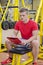 Young male personal trainer reading from clipboard