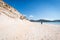 Young male photographer with dreadlocks at a sunny white sand beach