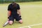 Young male player fell on his knees because of the loss in tennis match