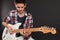 Young male playing electric guitar