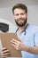 Young Male Radiologist Holding Clipboard In Examination Room