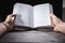 Young male reading an empty open book on a desk - insert your own message