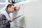 Young male repair worker examining car in automobile repair shop