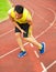 Young male runner suffering from leg cramp on the track