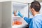 Young male scientist and laboratory freezer