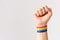 Young male showing his fist with LGBT pride bracelet
