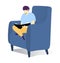 Young male sitting in a blue armchair reading a book relaxed and focused. Adult reader enjoying literature at home