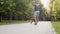 Young male skater having a walk in park with his dog