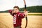 Young male sportsman targeting with bow in a traditional, medieval archer costume - Teenager archer practicing archery in nature