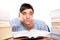 Young male student sitting with books on table