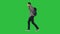 Young male student walking on isolated green background with bag and mobile phone on a Green Screen, Chroma Key.