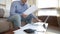 Young male studying documents at home office in living room