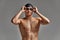 Young male swimmer preparing for the start, close-up portrait of a swimmer in a mask and a hat, gray background, copy