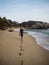 Young male tourist leaving traces behind footprints in tropical sand beach at Tayrona National Park Caribbean Colombia