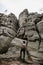 Young male traveler looks at a high rock, an obstacle in the way