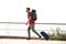 Young male traveler walking with suitcase and backpack