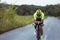 Young male triathlete riding a bicycle on the open road. Professional sportsman is engaged in triathlon on bright summer