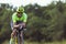 Young male triathlete riding a bicycle on the open road. Professional sportsman is engaged in triathlon on bright summer