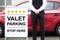 Young Male Valet Standing Near Valet Parking Sign