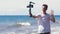 Young male vlogger filming travel story on the beach.