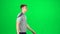 Young male walking on a Green Screen, Chroma Key. Side view