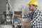 Young male worker examining machine in industry