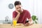 Young man addicted to smartphone having breakfast