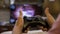 Young man addicted to video games holding gamepad playing first person shooter game console -