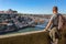 A young man admires the scenery of Porto, the Douro River. View of the bridge of San Luis.