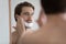 Young man apply foam shaving in bathroom