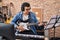 Young man artist playing electrical guitar at music studio