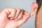 A young man asia using a stick of cotton swab for ears cleaning. Daily hygiene. Light gray background. Close up