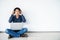 Young man asian sitting on the floor with using computer laptop smiling and listening nice music and feel relieved from stressed