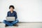 Young man asian sitting on the floor with using computer laptop smiling and listening nice music and feel relieved from stressed