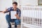 The young man assembling baby bed with instruction manual