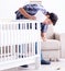 Young man assembling baby bed with instruction manual