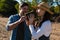 Young man assisting girlfriend drinking water in forest