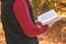 Young man in the autumn forest and reading book. Mental recreation in nature. Quiet country life. Escapism. Digital