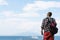 Young man with backpack standing with view on vulcano Vesuvius sea, ocean liner ship water craft. Travel and vacation concept.